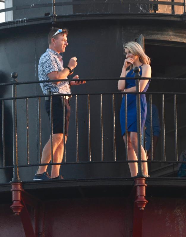 Lee Vandeloecht, who has a portable microphone and sound system, speaks about his love for his now fiancee, Megan Elizabeth Bailey, standing on the walkway of the Delaware Breakwater East End Lighthouse.