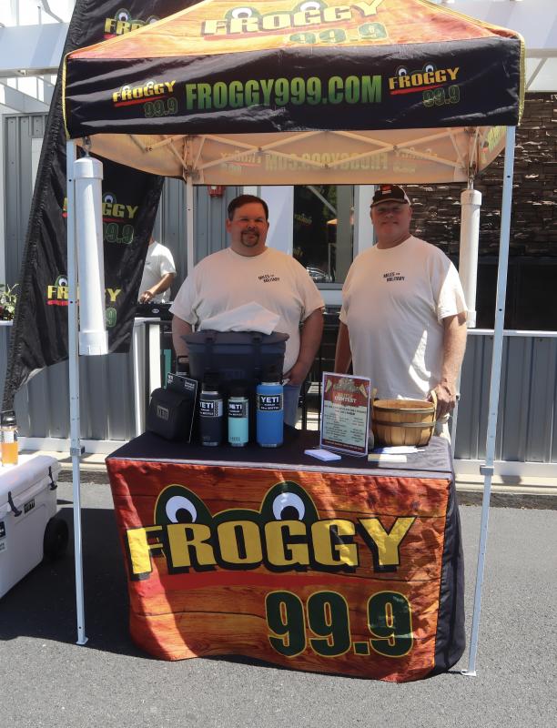 Ron Hall, left, and Dave Hovel present the Froggy 99.9 tent where attendees could sign up to participate in a Yeti raffle.
