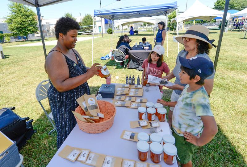 Jaonna Gates, left, of Gates Apothecary prepares a sale for Julianna Gomez, 10, Maria Ponce and Mateo Gomez, 8.
