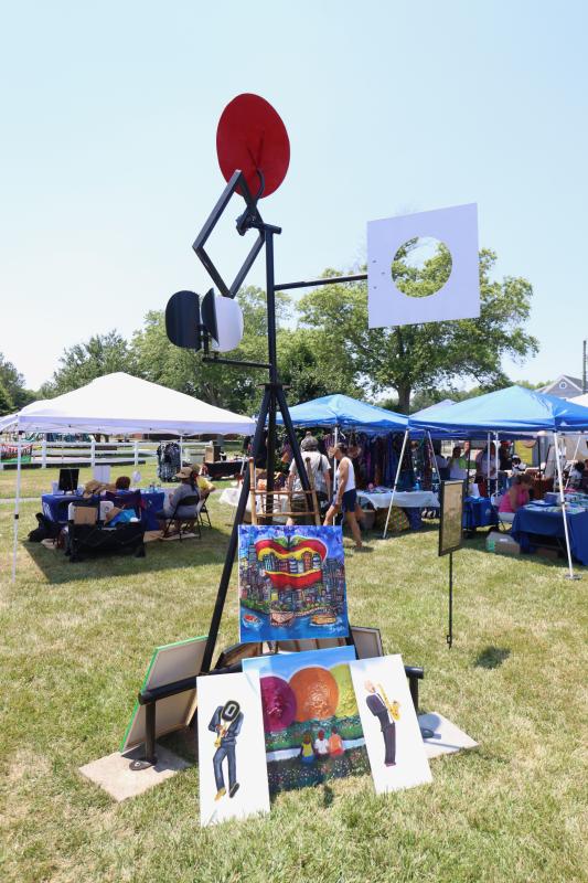 One of the kinetic sculptures erected by artist Paul Daniel in George H.P. Smith Park provides a makeshift stand for artwork by Theresa Taylor.
