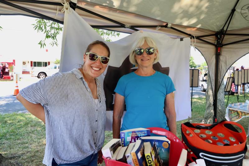 Jill DiPaolo, Lewes Public Library director, left, and Leslie Newman, library board member, hand out freebies during the event.