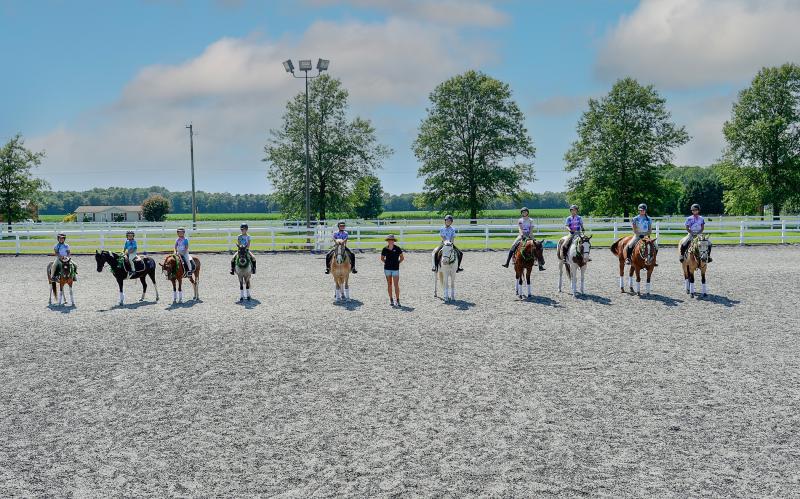 Campers line up after their performance. Shown are Kaly Walter and Mister Wonderful, Ainsley Garrity and Charlee, Aubrey Savage and Chicken, Lulu Miller and Chip, Summer Jackson and Blossom, Pairadice Equestrian owner Camille Kierstead, Callie Joseph and Bleu, Kiersten Buhay and Swan, Lizzy Hogan and Prince, Izzy Zigman and Jeb, and Lilly Ghabour and Butters.